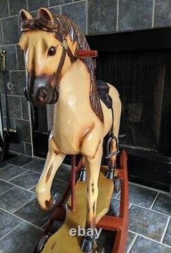 VINTAGE HANDCRAFTED WOODEN ROCKING HORSE with cast iron wheels & leather saddle